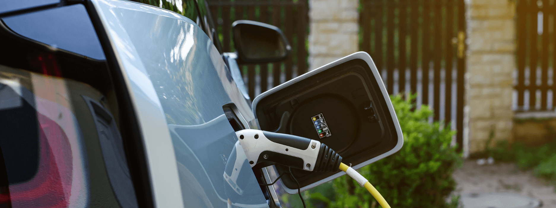 Electric vehicle charger charging electric vehicle in home driveway