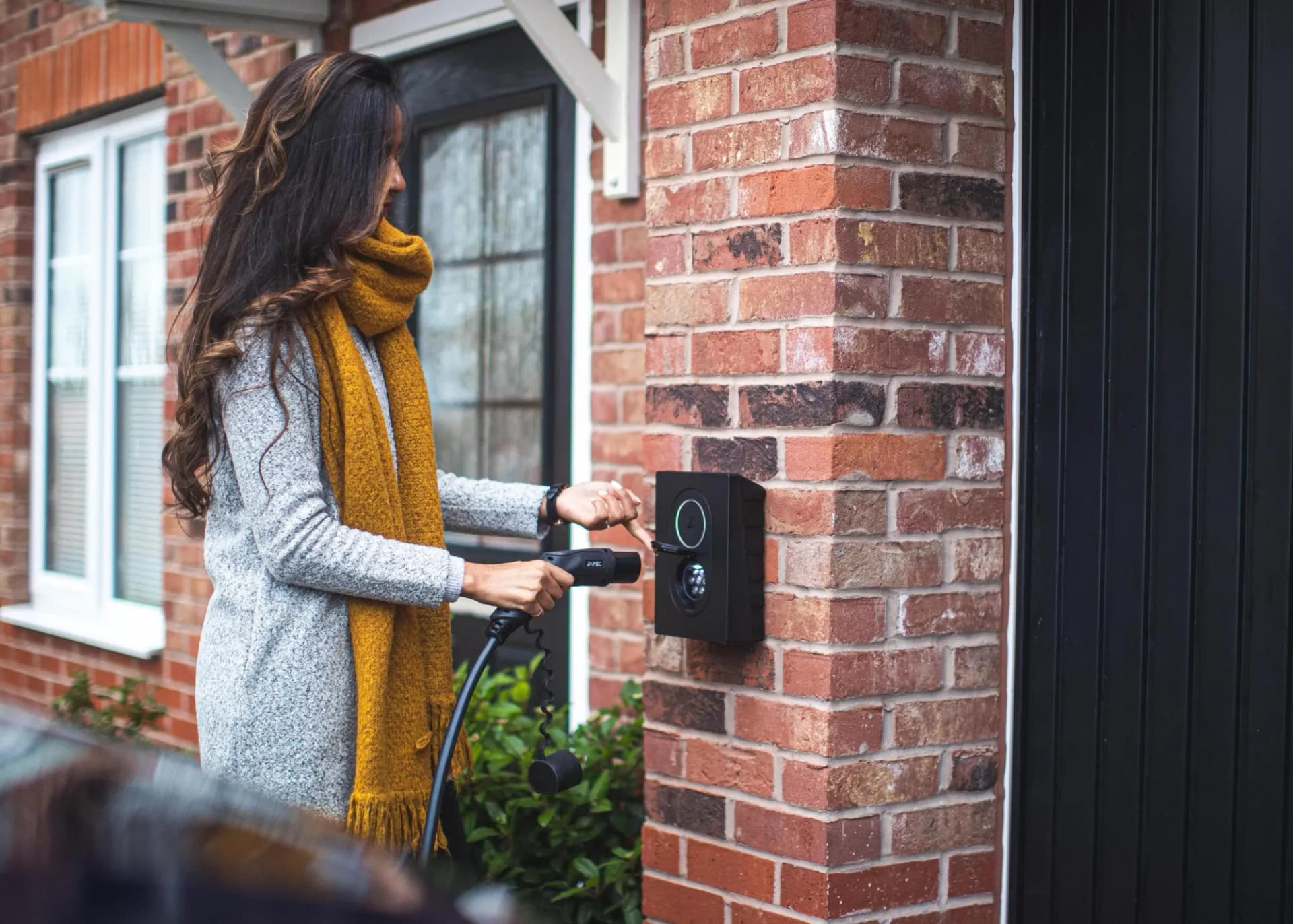 lady with scarf charging an EV at home with level 2 charger lectrium