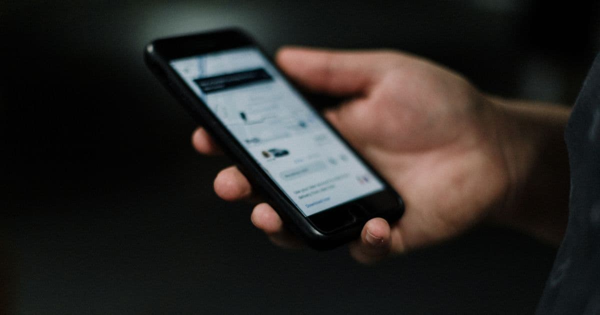 Man viewing a ride-sharing app on an iPhone